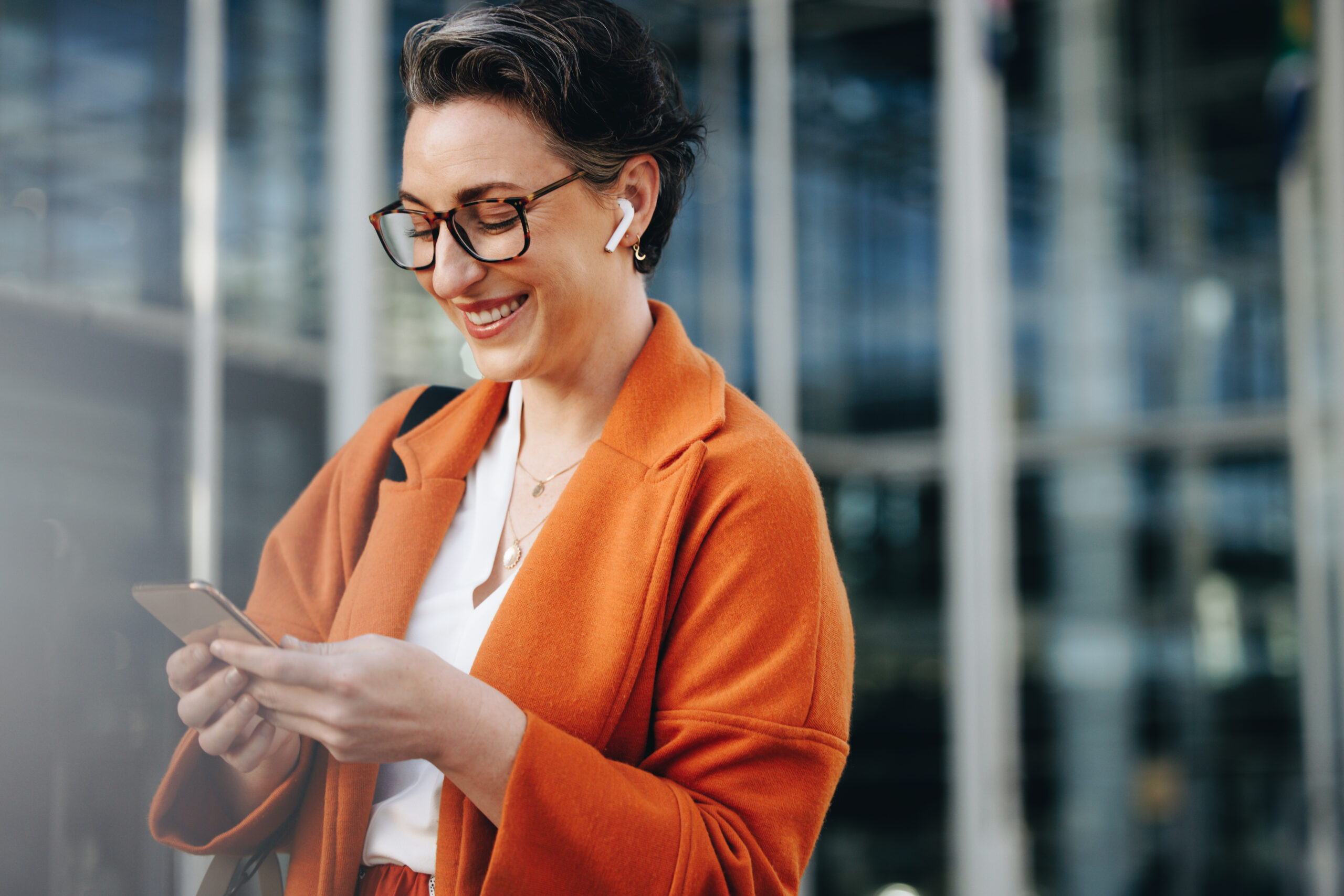 Smiling businesswoman reading a text message on her phone